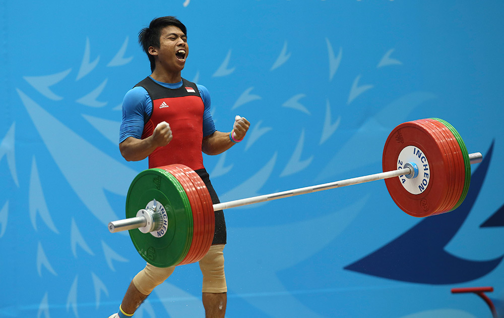 Deni After A Successful Lift In the Men's 69 Kg Weightlifting Competition