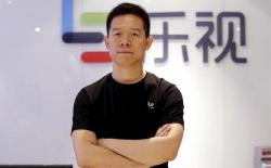Jia Yueting, co-founder and head of Le Holdings Co Ltd, poses for a photo in front of a logo of his company in Beijing
