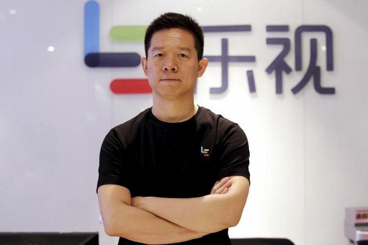 Jia Yueting, co-founder and head of Le Holdings Co Ltd, poses for a photo in front of a logo of his company in Beijing