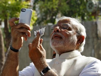 Hindu nationalist Narendra Modi, prime ministerial candidate for India’s main opposition BJP, takes “selfie” with mobile phone after casting his vote at a polling station during seventh phase of India’s general election in Ahmedabad