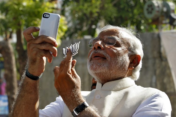 Hindu nationalist Narendra Modi, prime ministerial candidate for India’s main opposition BJP, takes “selfie” with mobile phone after casting his vote at a polling station during seventh phase of India’s general election in Ahmedabad