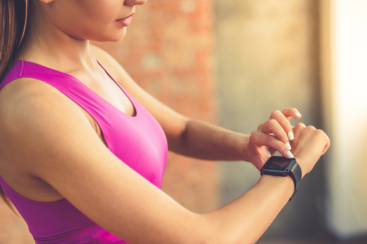 Woman using Fitbit shutterstock website