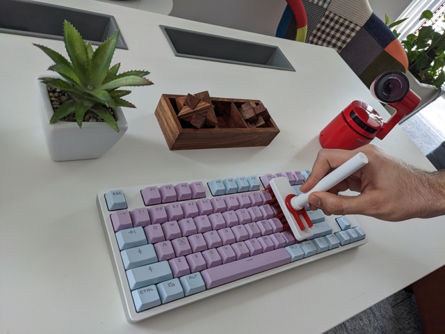Use a brush to clean between the keycaps.