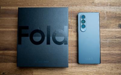 Samsung Galaxy Z Fold 4 placed with it's retail packaging on a wooden surface