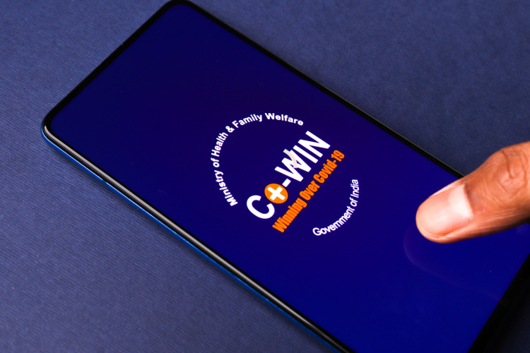 The CoWIN app open on a mobile device, placed on a blue background