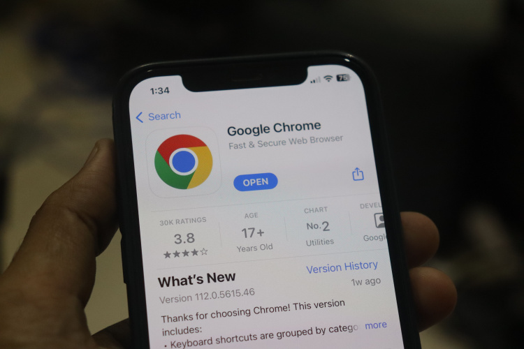 The Google Chrome app installed on an iPhone and is held by a hand