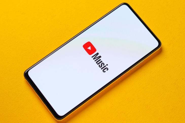 YouTube Music logo on a smartphone placed on a yellow background