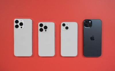 iPhone 15 series dummy models placed face down on a red surface