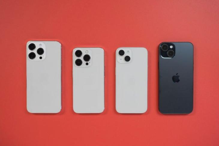 iPhone 15 series dummy models placed face down on a red surface