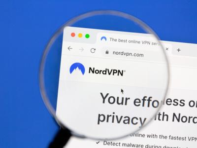 This image depicts the Nord VPN webpage under a magnifying glass