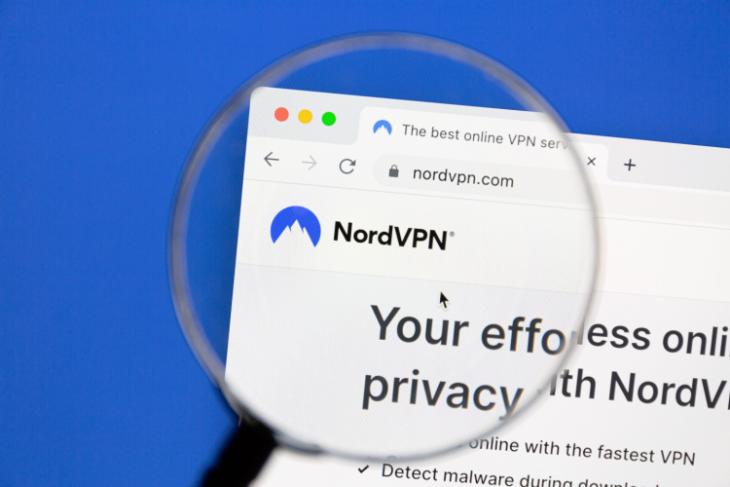 This image depicts the Nord VPN webpage under a magnifying glass