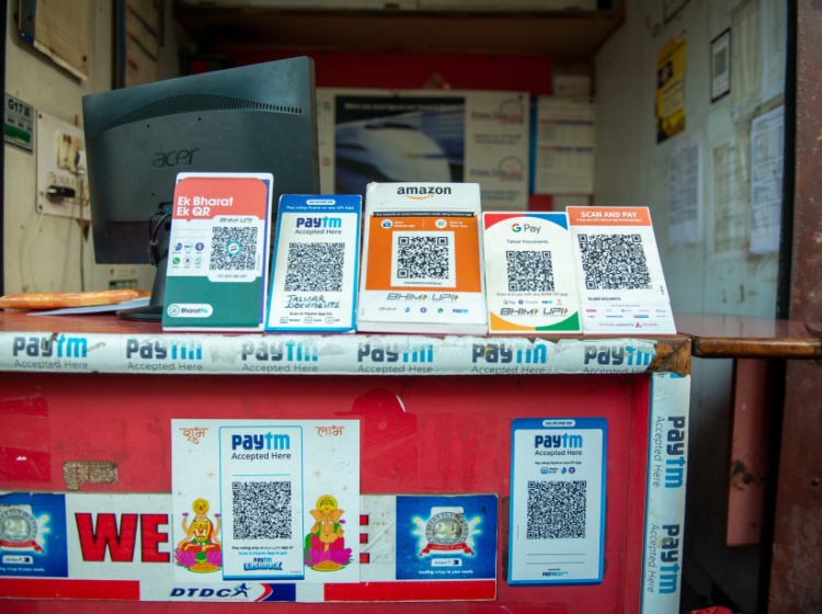 Several payment placards are displayed in front of a store that facilitates UPI payments by scanning QR codes
