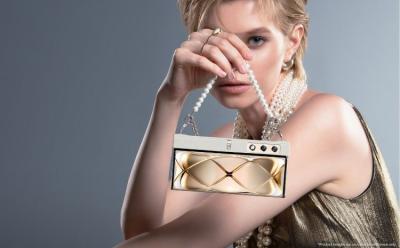 This image depicts a female model holding the brand new concept foldable smartphone from Honor, the V Purse like a purse