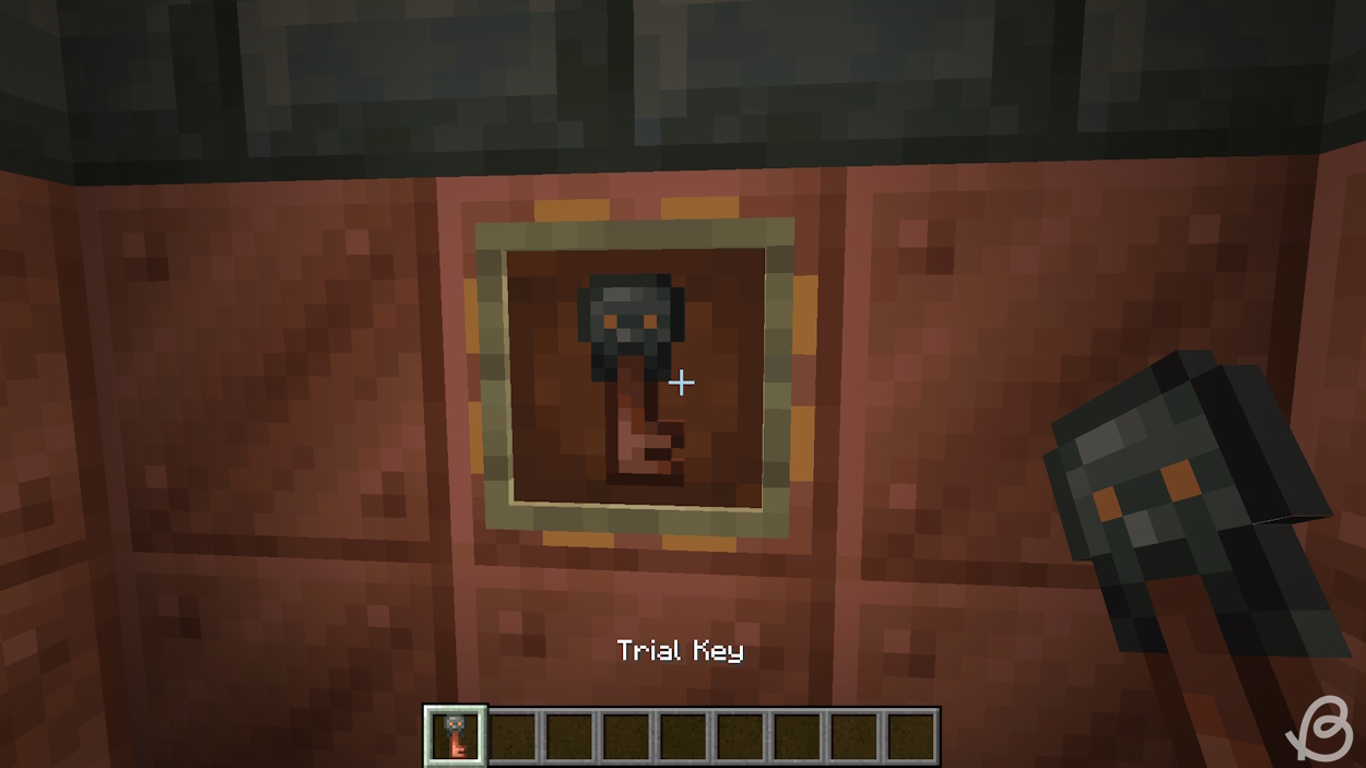 Player holding the trial key and the trial key in the item frame in Minecraft