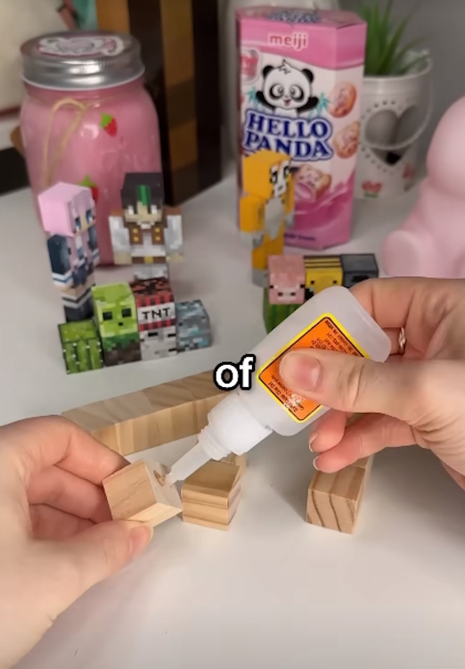 YouTuber gluing wooden cubes together to mimic pixels of a Minecraft item