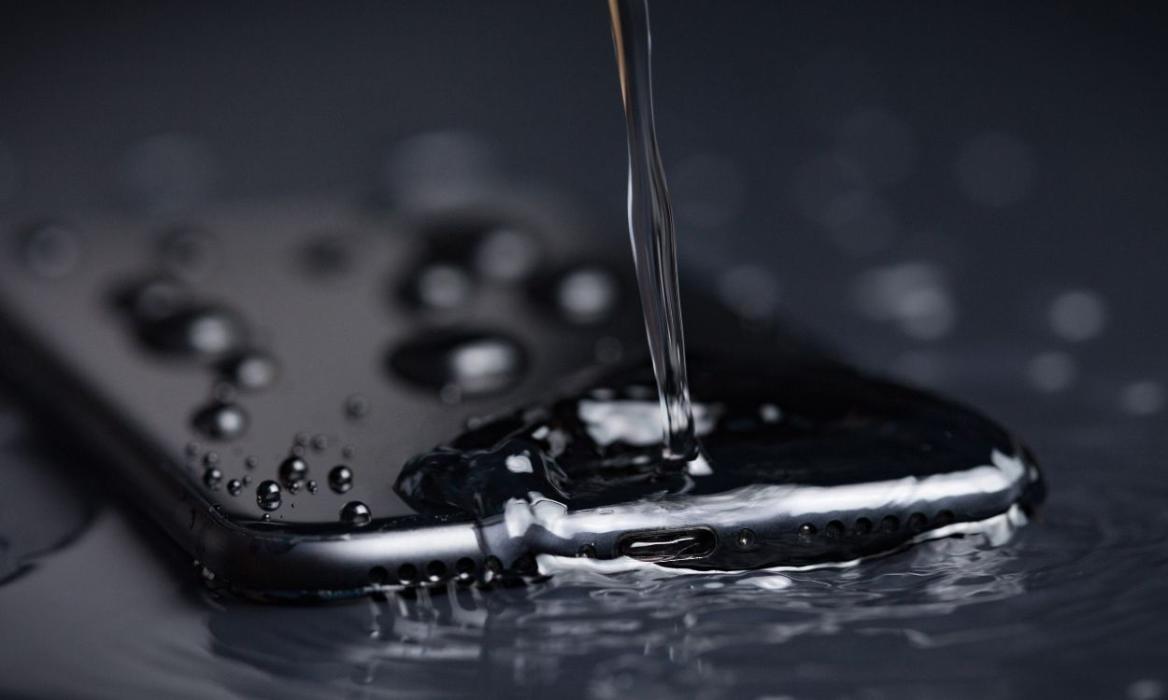 Close Up of Water pouring on the back side of a Black iPhone