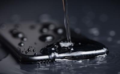 Close Up of Water pouring on the back side of a Black iPhone