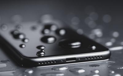 Closeup of water droplets on a black iPhone