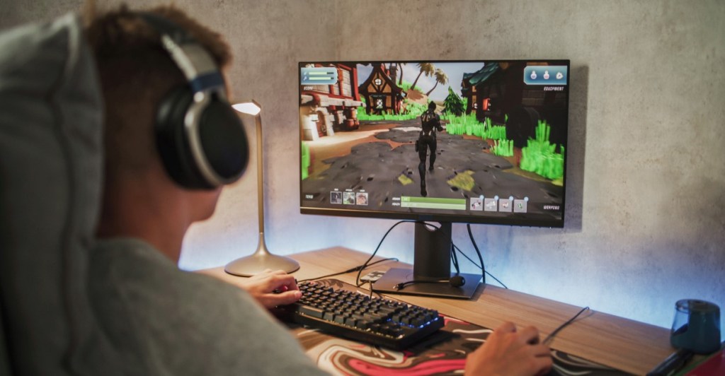 person playing a Game on their PC featuring headphones, keyboard | discord status ideas