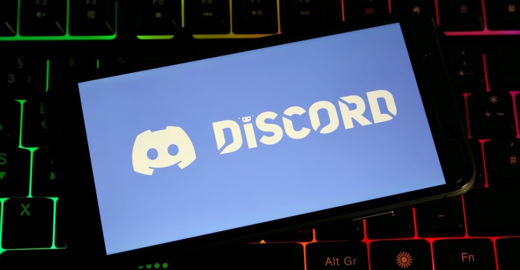 phone with Discord logo placed on top of a mechanical backlit keyboard 