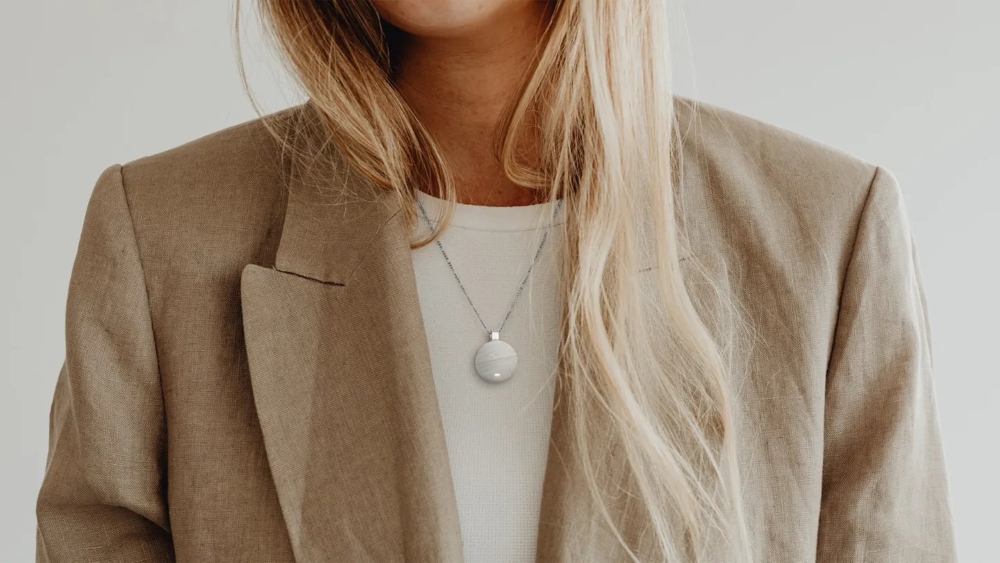 A blonde girl wearing Omi in white color pendant