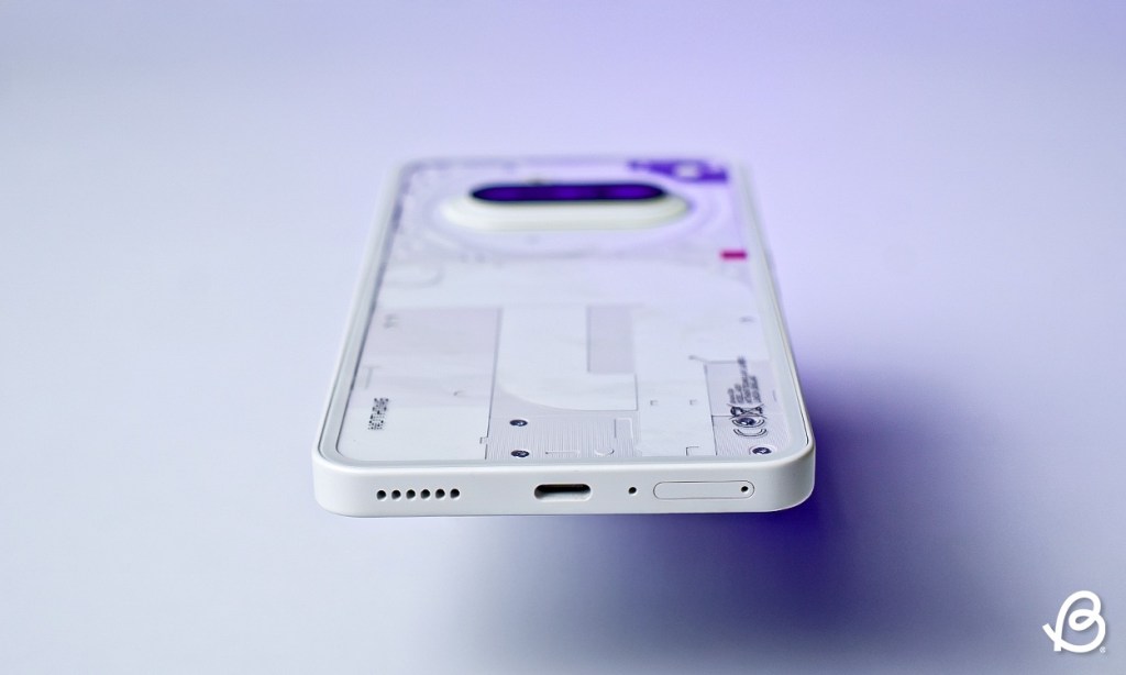 Nothing Phone (3a) in white laying flat showing the bottom USB Type C port